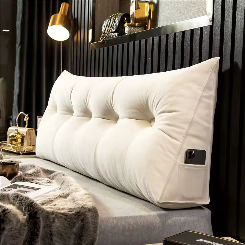 Ivory tufted Hammora headboard pillow with an angled side profile and side pocket, positioned on a bed