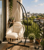 Cream hammock chair with freestanding black stand on an apartment balcony